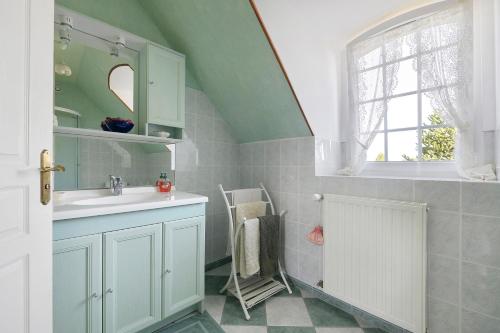 a bathroom with a sink and a window at La tourelle de la croix in Picauville