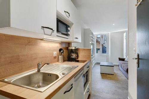 a kitchen with a sink and a microwave at Petit cocon cosy en hyper centre in Villard-de-Lans