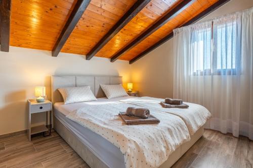 a bedroom with a bed with two towels on it at Villa Loznati in Cres