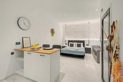 a bedroom with a bed and a clock on the wall at Doliva Studio 6 with private pool in Agios Gordios