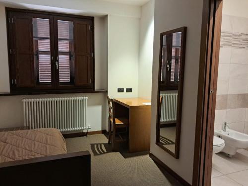 a bedroom with a bed and a sink and a mirror at Domus Laetitiae Assisi in Assisi