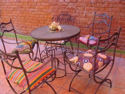 una mesa y sillas con un gato sentado encima en Intiaconcagua Habitaciones Familiares en Luján de Cuyo