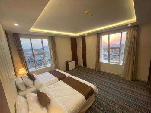 a hotel room with a large bed and windows at نزل خيال جيزان in Jazan