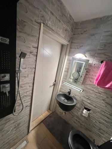 a bathroom with a sink and a stone wall at Tchaopremium in Lomé