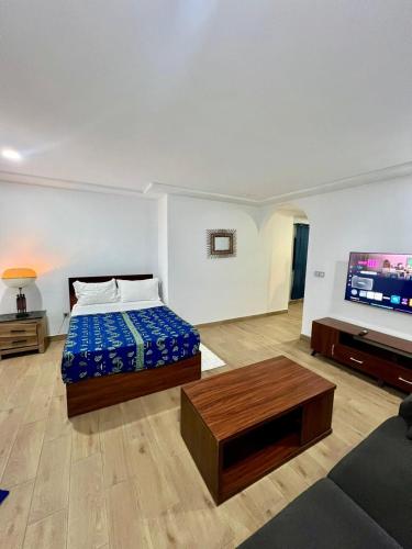 a bedroom with a bed and a flat screen tv at Tchaopremium in Lomé