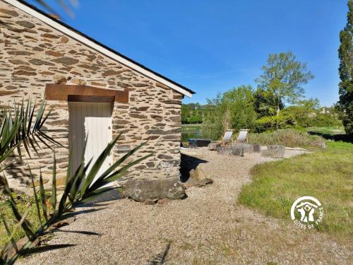 a stone building with a door and a yard at La Roche des Eaux Vives, 2 personnes in Fromentières