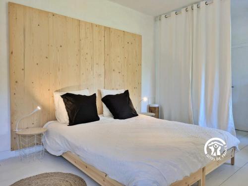 a bedroom with a large bed with a wooden headboard at La Roche des Eaux Vives, 2 personnes in Fromentières