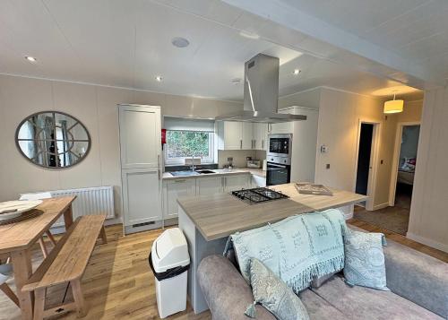 a kitchen and living room with a table and a dining room at Meadows End Lodges in Cartmel