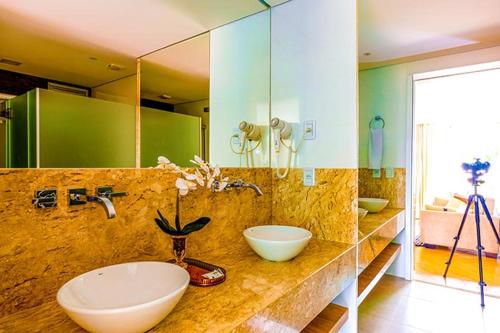 a bathroom with two sinks and a large mirror at Prive Thermas Hotel by WAM Experience in Caldas Novas