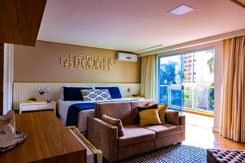 a bedroom with a bed and a couch in front of a bed at Prive Thermas Hotel by WAM Experience in Caldas Novas