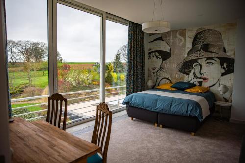 a bedroom with a bed and a large window at Villa Bianca in Dalhem