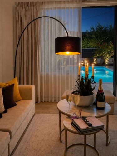 a living room with a couch and a table with wine glasses at Villa Almihauss - Adults Only in Afantou
