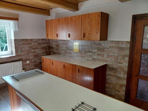 a kitchen with wooden cabinets and a counter top at Horská chata U Pekařů in Pec pod Sněžkou