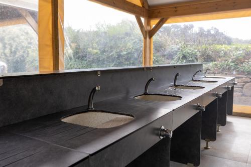 a row of sinks in a public restroom at Camping RCN Port l'Epine in Trélévern