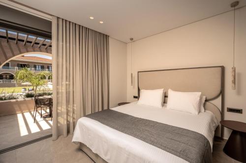 a bedroom with a large bed and a balcony at Hotel Palmyra in Argassi