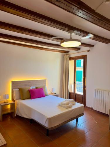 a bedroom with a large white bed with pink pillows at Hotel Casa Manolet 