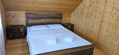 a bedroom with a bed in a wooden room at კერა მთაში Kera Mtashi in Ambrolauri