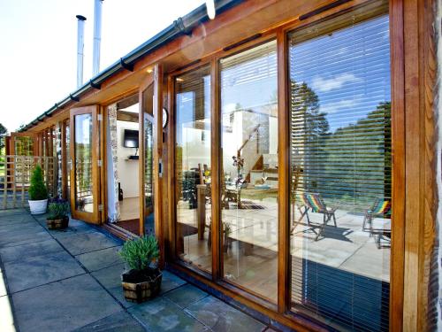 a house with sliding glass doors on a patio at Bluetit Cottage in Kings Nympton
