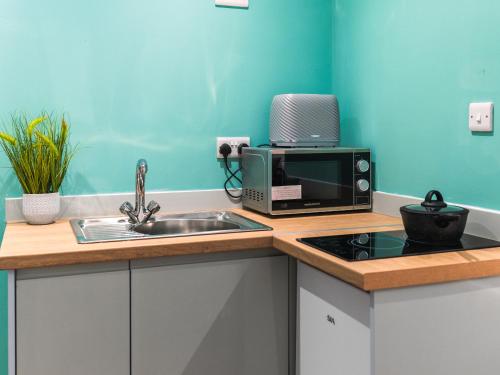 a kitchen with a sink and a microwave at Hilltop Apartment 6 - Uk50598 in Earl Shilton