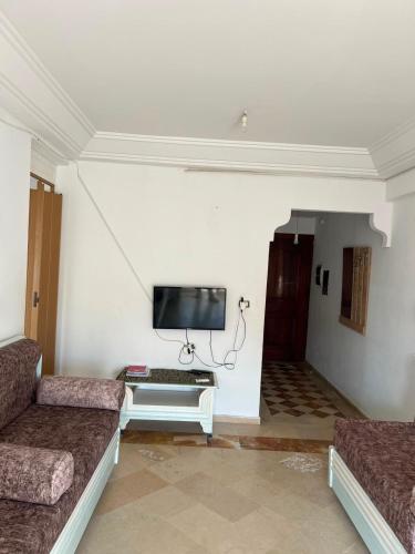 a living room with two couches and a flat screen tv at Dar El vague in Hiboun