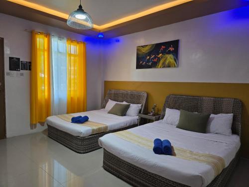 two beds in a hotel room with blue lights at Jade Resort - Bauang, La Union in Bauang