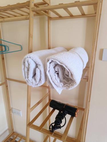 a wooden bunk bed with towels on a ladder at Pai Fields Good in Pai
