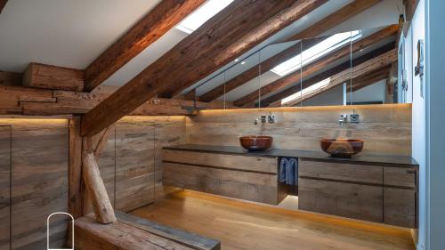 a bathroom with two sinks in a wooden wall at Exklusives Gut Stohrerhof am See in Dießen am Ammersee