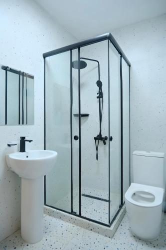 a bathroom with a shower and a toilet and a sink at GAIA Hostel in Türkistan