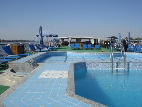a large swimming pool with blue lounge chairs at Sun Nile Cruise in Aswan
