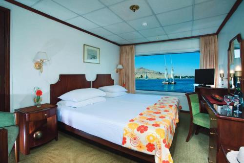 a bedroom with a bed and a large window at Sun Nile Cruise in Aswan