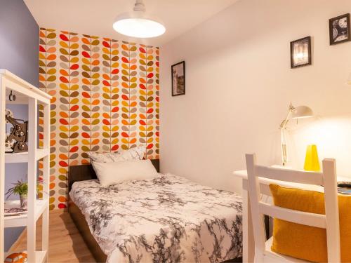 ein kleines Schlafzimmer mit einem Bett und einer farbenfrohen Wand in der Unterkunft Mr Franks in Sulzbach-Rosenberg