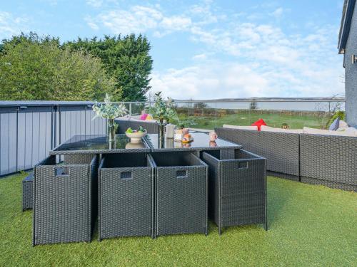 a patio with four wicker tables on the grass at North Plain Barn in Bowness-on-Solway