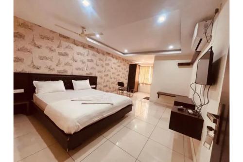 a bedroom with a bed and a tv in it at FabHotel Udupi in Mysore