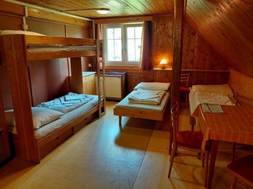 a room with two bunk beds and a table at Horská chata U Pekařů in Pec pod Sněžkou