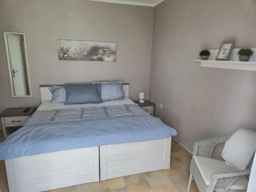 una camera da letto con un letto con lenzuola blu e una sedia di House Eifelglück a Großlittgen