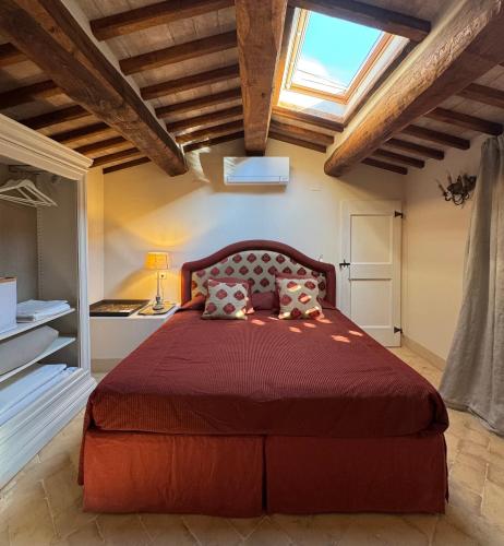 a bedroom with a large red bed with a window at Podere San Pietro in Cetona