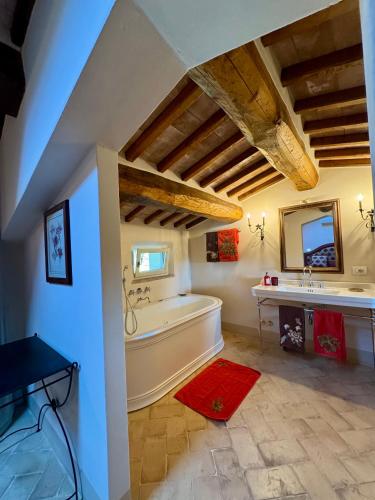 a bathroom with a tub and a sink and a mirror at Podere San Pietro in Cetona