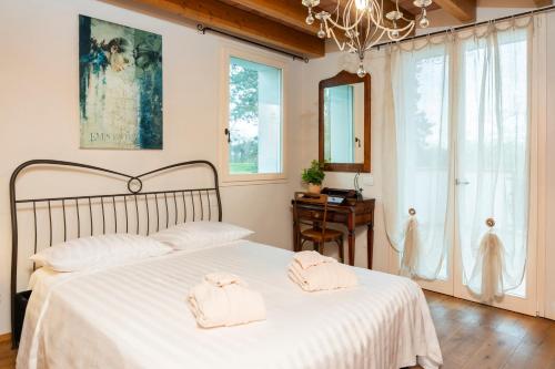 a bedroom with a bed with white sheets and a chandelier at Podere Luna Stella in Bellaria-Igea Marina