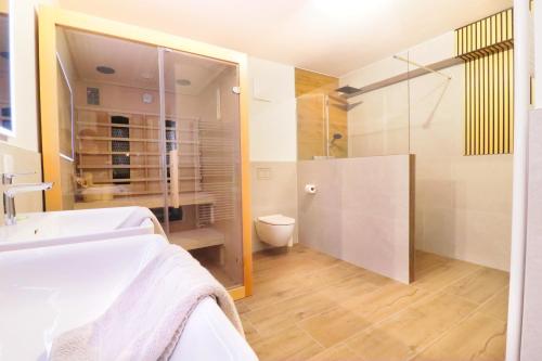 a bathroom with a sink and a shower and a toilet at Apartment ZellPeak in Zell am See