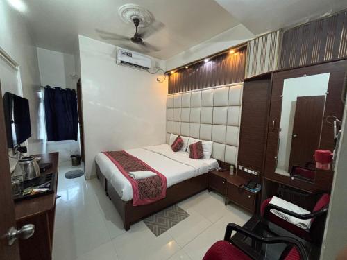 a hotel room with a bed and a mirror at hotel wisdom celebration in Motīhāri