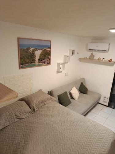 a bedroom with a bed and a couch at Oceanview Apart Residence in Natal