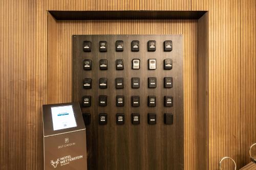 an elevator with a bunch of buttons on a wall at Hotel Wetterstein by keyone in Seefeld in Tirol