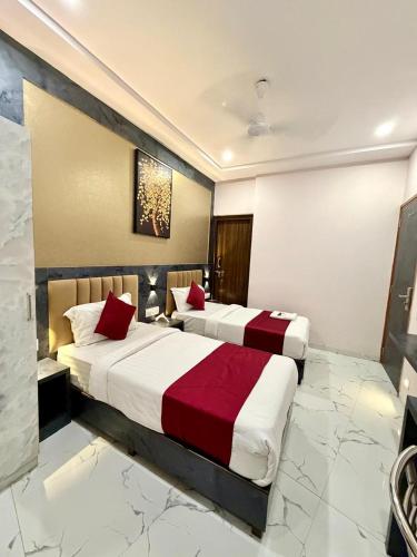 two beds in a hotel room with red pillows at Hotel Classy Comfort Business Family Hotel in Mumbai