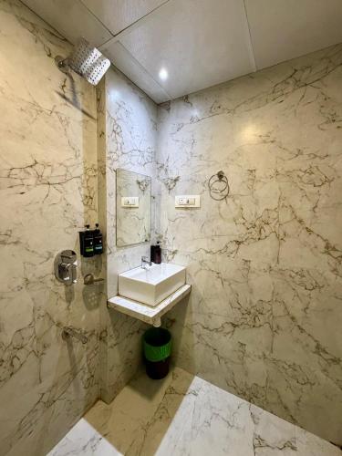 a bathroom with a sink and a marble wall at Hotel Classy Comfort Business Family Hotel in Mumbai