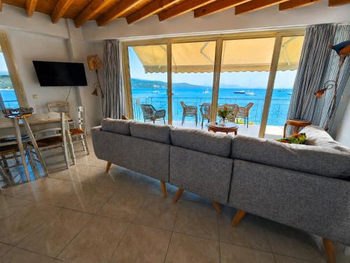 a living room with a couch and a view of the ocean at SALTY BREEZE Beachfront Apartment in Lygia