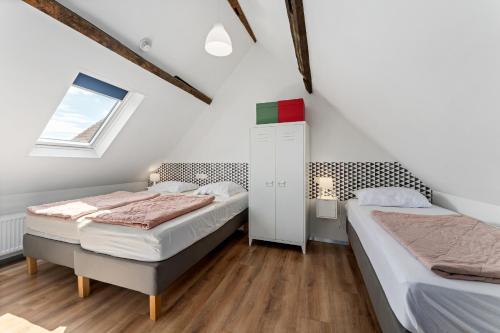 two beds in a room with white walls and a window at Barbara' s Guesthouse in Watou