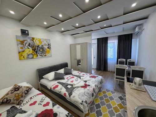a room with two beds and a kitchen in it at Apartmani Slađo in Trebinje