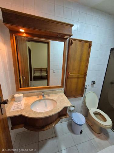 ein Badezimmer mit Waschbecken, Toilette und Spiegel in der Unterkunft River Hotel in Uruguaiana
