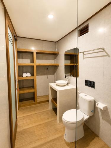 a bathroom with a toilet and a sink at Luling Guesthouse in Badung