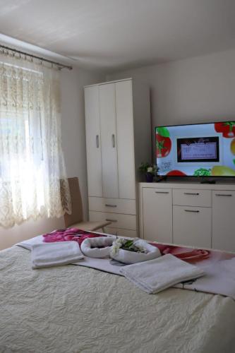 a bedroom with a bed with towels on it at Apartman Anastasija in Guča